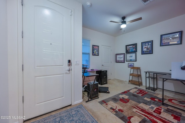 carpeted office space featuring baseboards, visible vents, and a ceiling fan