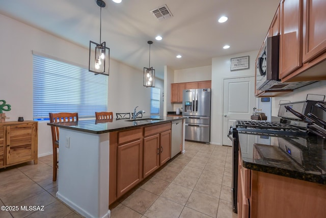 kitchen with visible vents, light tile patterned floors, a sink, and stainless steel appliances