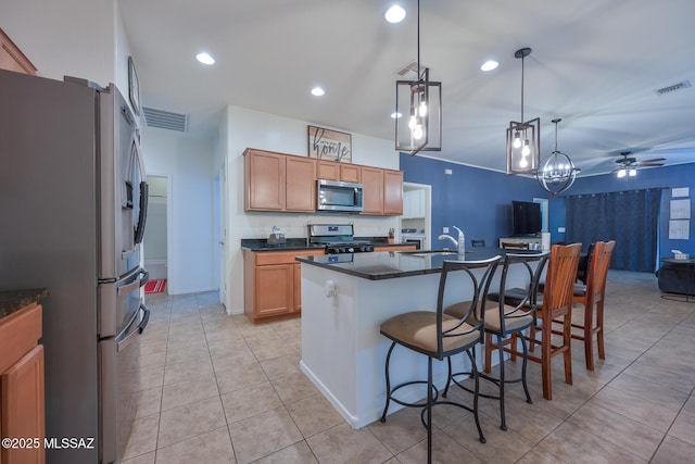 kitchen featuring visible vents, stainless steel appliances, dark countertops, a breakfast bar area, and light tile patterned floors