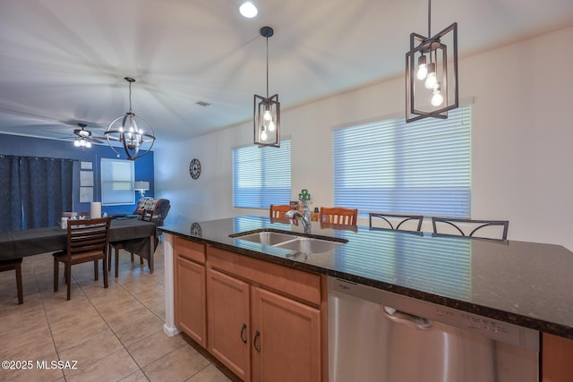 kitchen featuring light tile patterned flooring, a wealth of natural light, a sink, and stainless steel dishwasher
