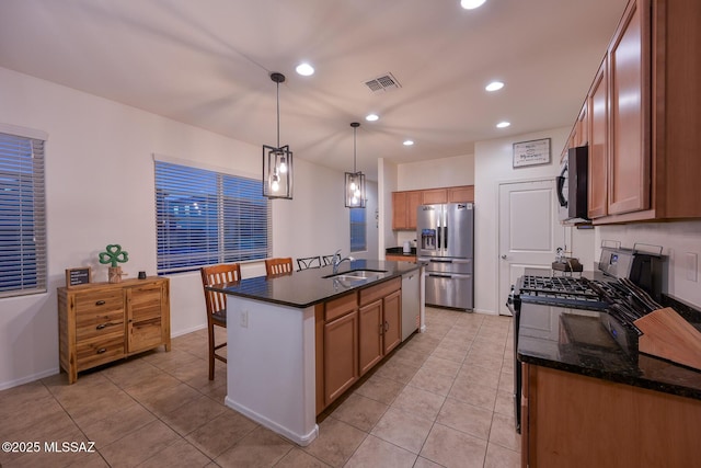 kitchen with visible vents, stainless steel fridge, dishwasher, gas stove, and a sink