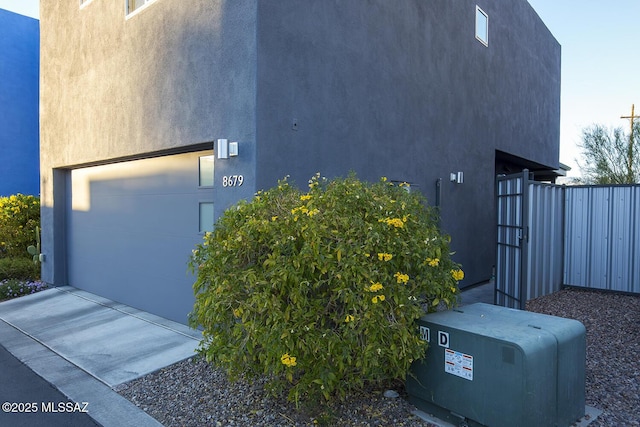 view of side of home featuring fence and stucco siding