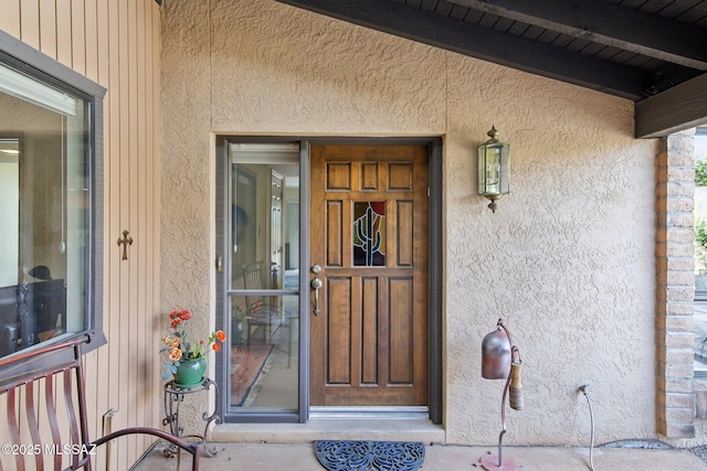 property entrance with stucco siding