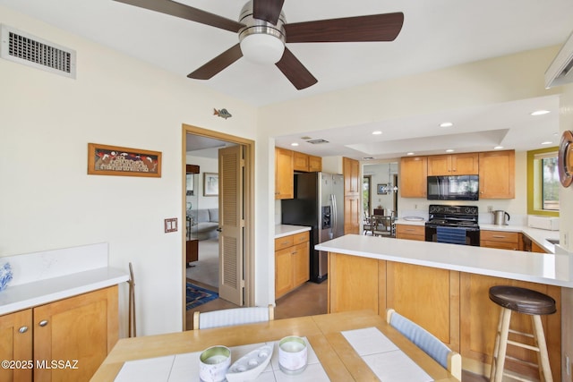 kitchen with visible vents, a peninsula, recessed lighting, black appliances, and light countertops