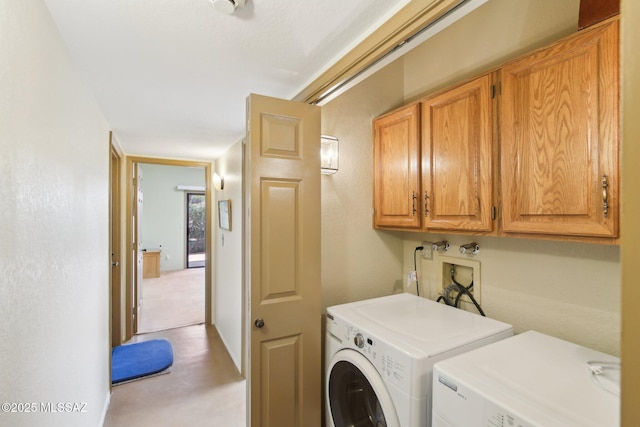 clothes washing area with cabinet space and independent washer and dryer