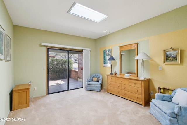 living area featuring baseboards, a skylight, and carpet flooring