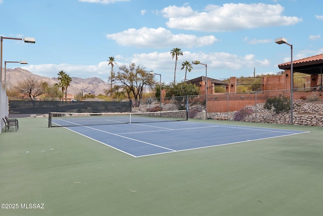 view of sport court featuring a mountain view and fence