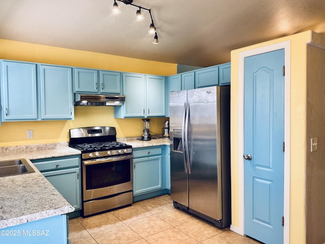 kitchen featuring blue cabinets, under cabinet range hood, and stainless steel appliances