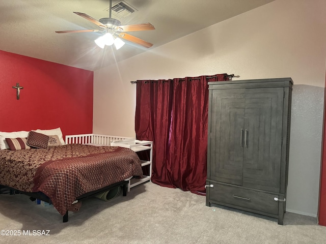 carpeted bedroom with visible vents, vaulted ceiling, and a ceiling fan