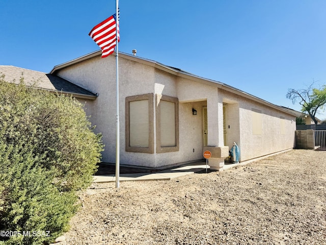 back of house featuring a patio, fence, and stucco siding