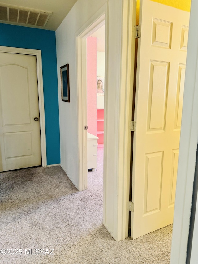 hall featuring visible vents and carpet flooring