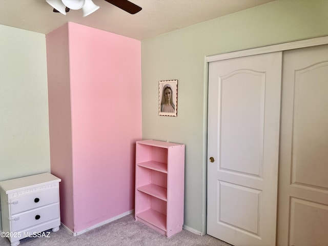 bedroom featuring a closet, light carpet, ceiling fan, and baseboards