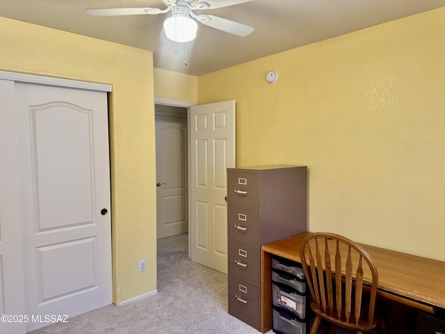 home office with a ceiling fan and light colored carpet