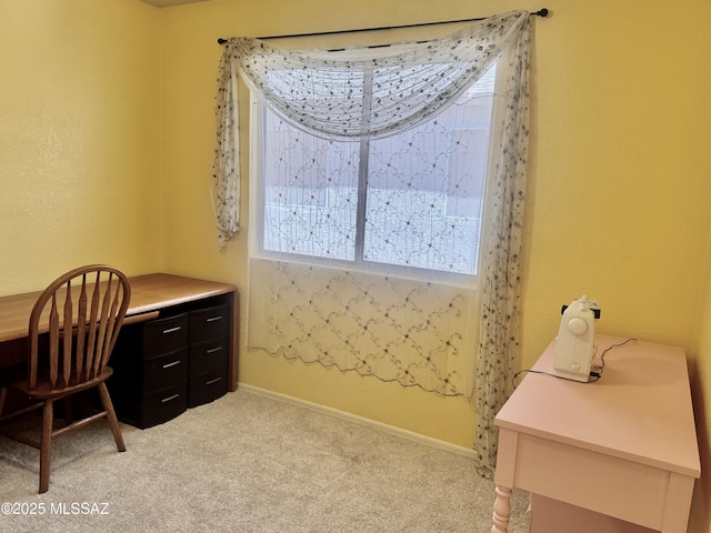 office area featuring light carpet and baseboards