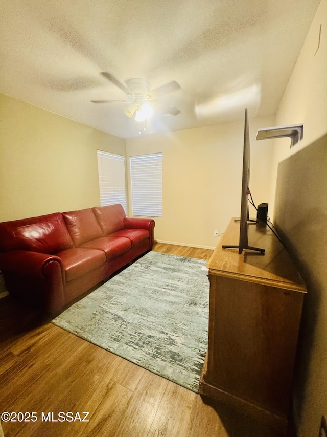 living room featuring a textured ceiling, a ceiling fan, and wood finished floors