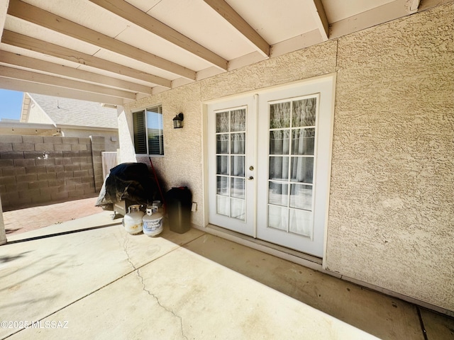 view of patio featuring french doors and fence