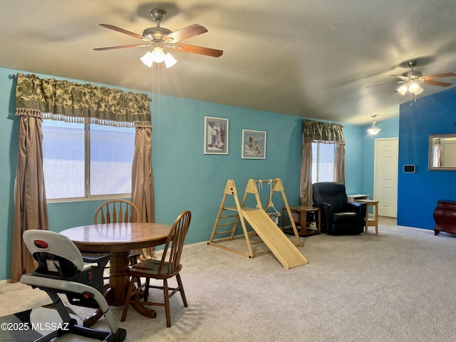 dining room with a textured ceiling, carpet flooring, a ceiling fan, and baseboards