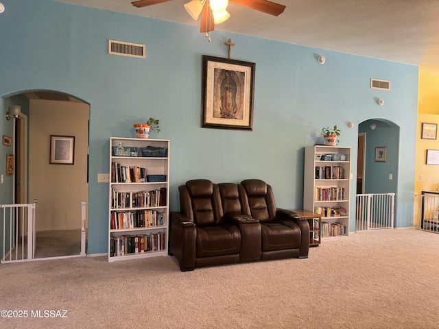 sitting room featuring carpet floors, arched walkways, and visible vents