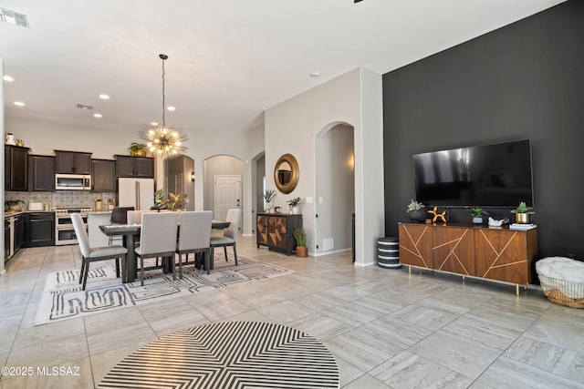 dining room featuring an inviting chandelier, visible vents, arched walkways, and recessed lighting