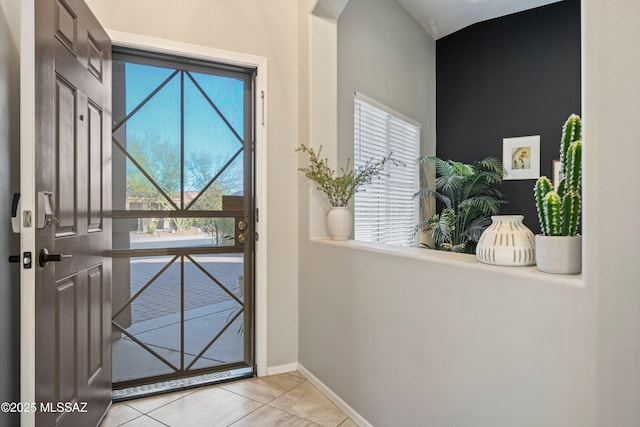 doorway to outside featuring baseboards and tile patterned floors