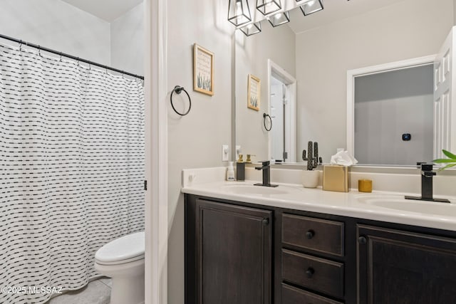 full bath featuring double vanity, tile patterned flooring, a sink, and toilet