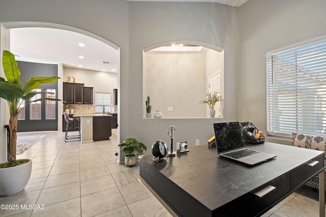 interior space featuring decorative backsplash, a wealth of natural light, and tile patterned floors