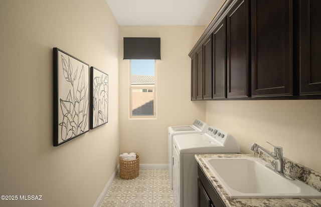 laundry area featuring independent washer and dryer, baseboards, a sink, and cabinet space