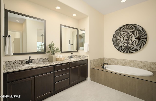 full bath featuring double vanity, a sink, a bath, and recessed lighting