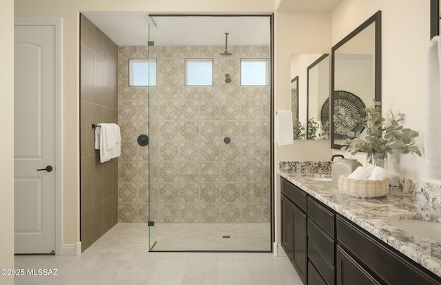 full bathroom featuring double vanity, a walk in shower, tile patterned floors, and a sink