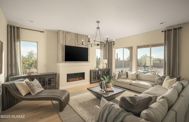 living room with a healthy amount of sunlight, wood finished floors, and a notable chandelier