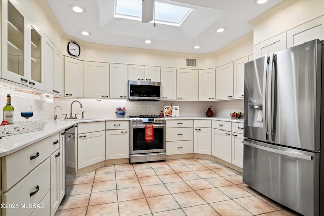 5822 E S Wilshire Dr, Tucson, AZ 85711 - kitchen with appliances with stainless steel finishes, a skylight, a sink, recessed lighting, and decorative backsplash