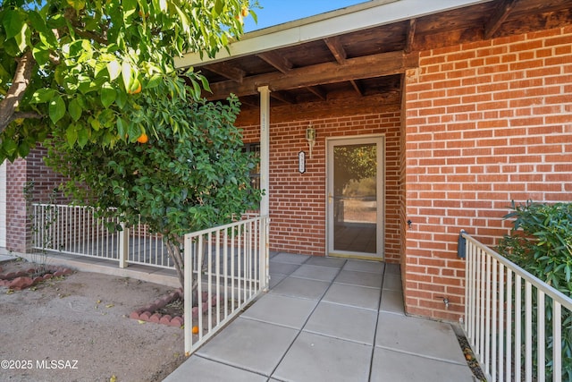 view of exterior entry featuring brick siding