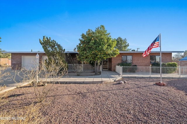 5822 E S Wilshire Dr, Tucson, AZ 85711 - view of front of home with brick siding, an attached garage, and fence