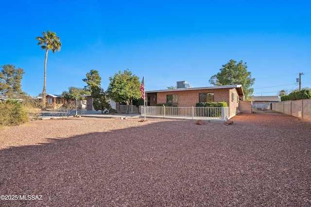 exterior space featuring fence and brick siding