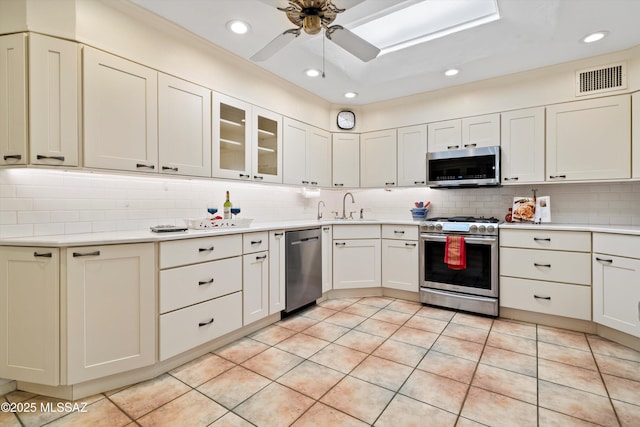 kitchen with tasteful backsplash, visible vents, light countertops, appliances with stainless steel finishes, and a sink