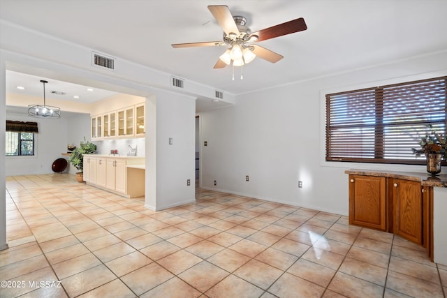 kitchen with light tile patterned floors, visible vents, ceiling fan, and built in desk