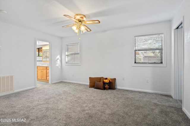 unfurnished room featuring a ceiling fan, baseboards, visible vents, and light carpet