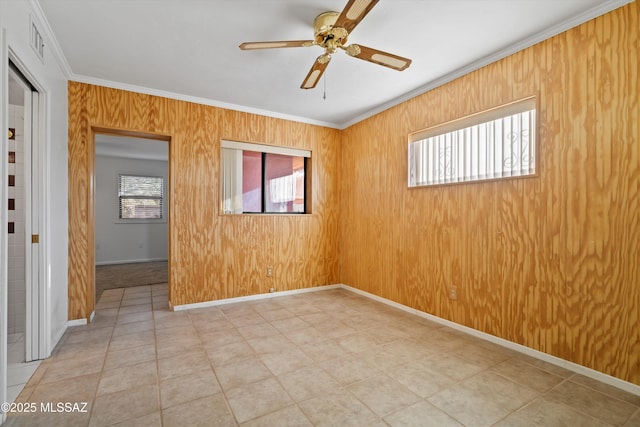 unfurnished room featuring a wealth of natural light, visible vents, ceiling fan, and crown molding