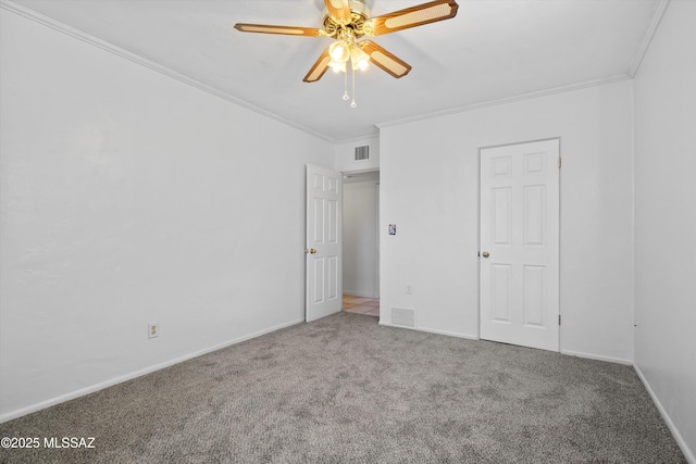 unfurnished bedroom featuring crown molding, carpet, visible vents, and baseboards