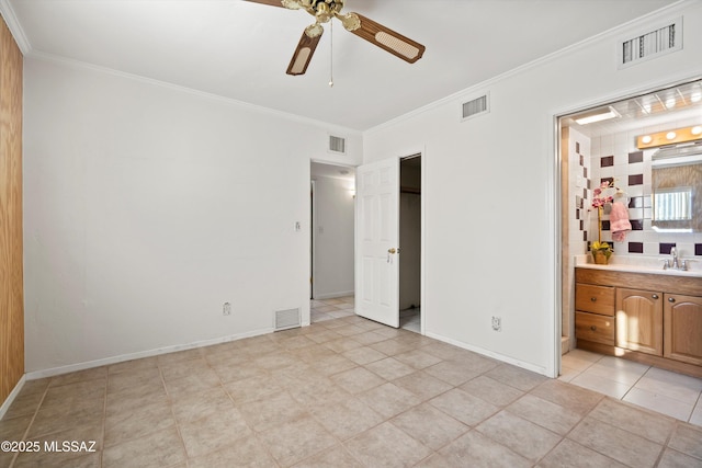 5822 E S Wilshire Dr, Tucson, AZ 85711 - unfurnished bedroom featuring crown molding, light tile patterned floors, ensuite bath, a sink, and baseboards