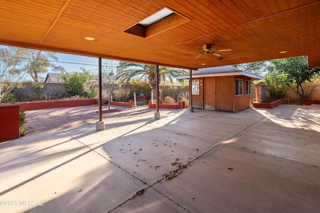 view of patio featuring an outbuilding, fence, and ceiling fan