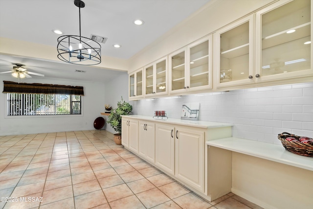 kitchen with tasteful backsplash, hanging light fixtures, light countertops, and ceiling fan