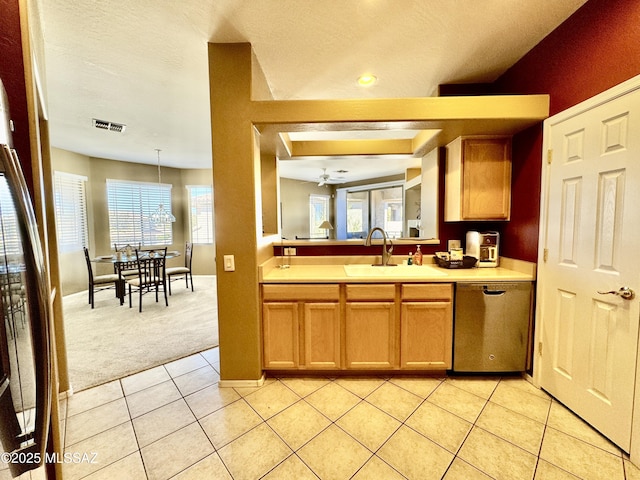 kitchen with a sink, stainless steel dishwasher, light tile patterned floors, and light countertops