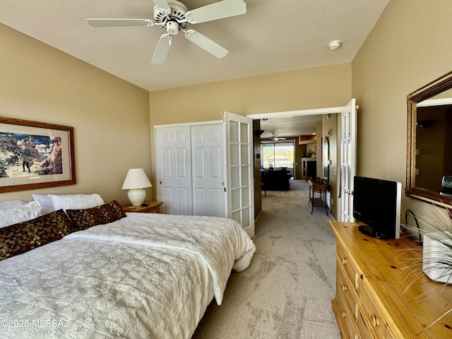 bedroom featuring light carpet, ceiling fan, and a closet