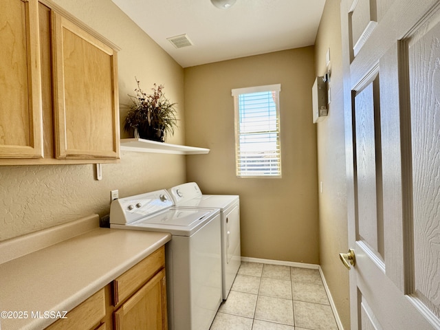 clothes washing area with visible vents, baseboards, washing machine and dryer, light tile patterned floors, and cabinet space