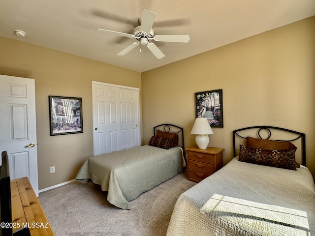 carpeted bedroom featuring a closet, baseboards, and ceiling fan