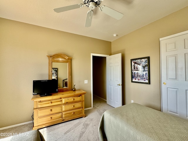 bedroom with light colored carpet, a ceiling fan, and baseboards