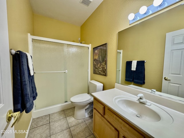 bathroom with visible vents, toilet, a stall shower, tile patterned flooring, and vanity