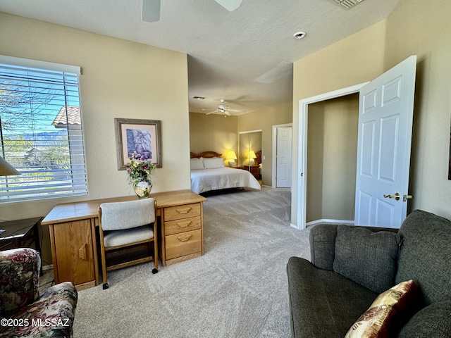 bedroom with a textured ceiling, a ceiling fan, baseboards, and light carpet