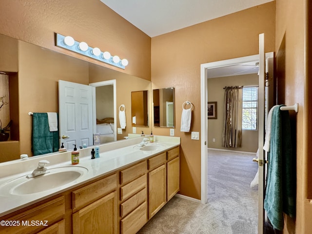 bathroom with double vanity, baseboards, and a sink